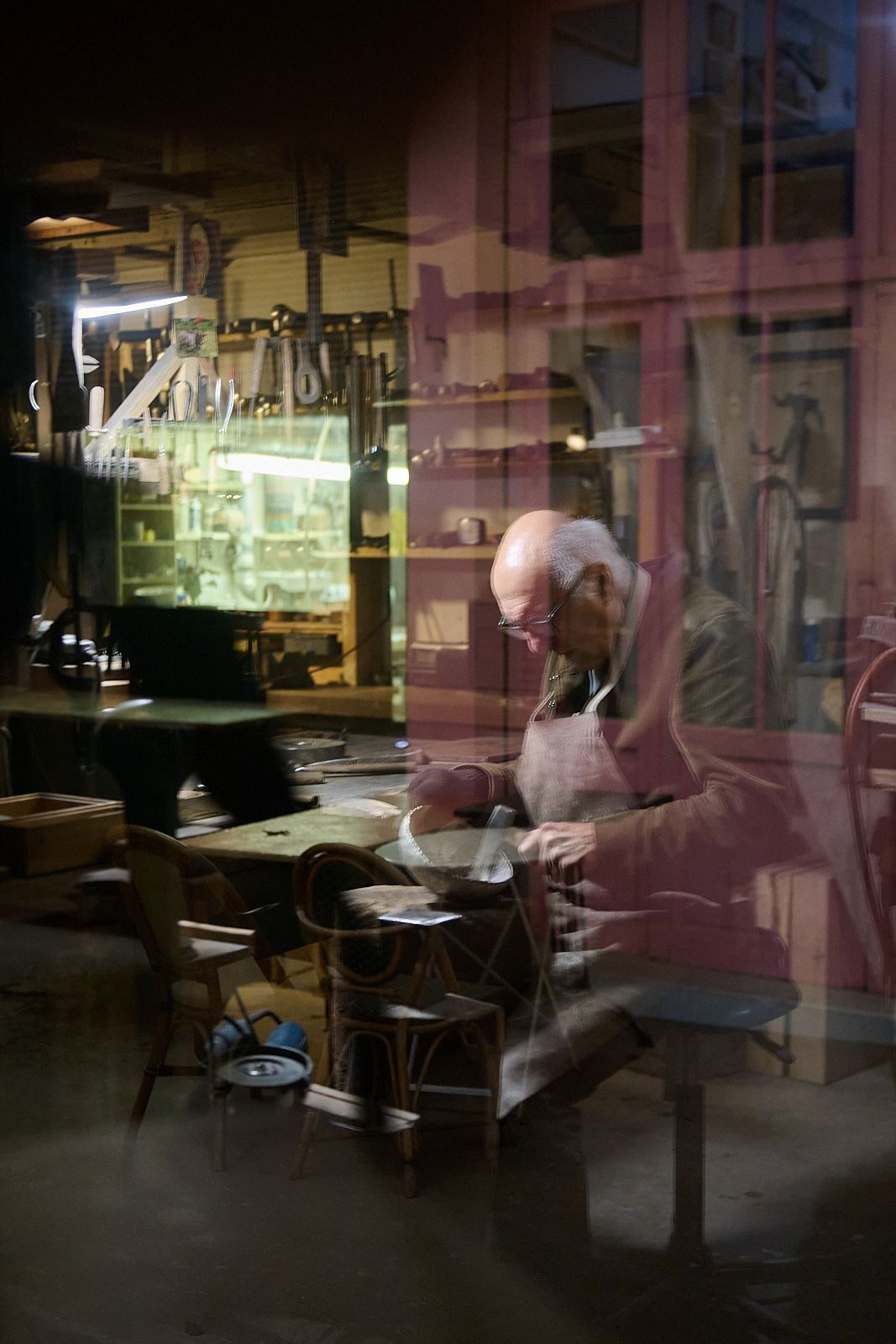Artisan en reflet dans sa vitrine