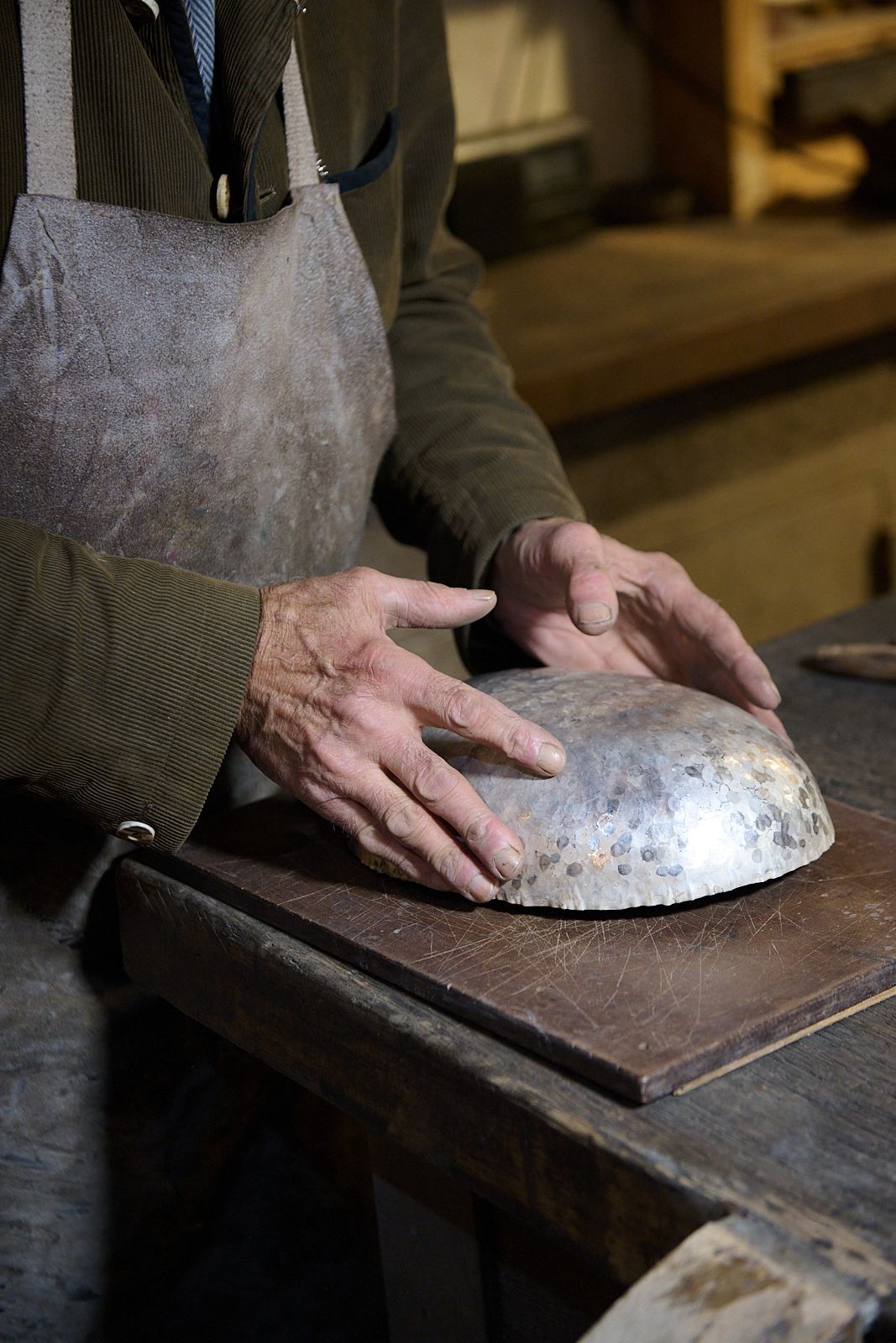 main d'artisan agé tenant un bol en argent