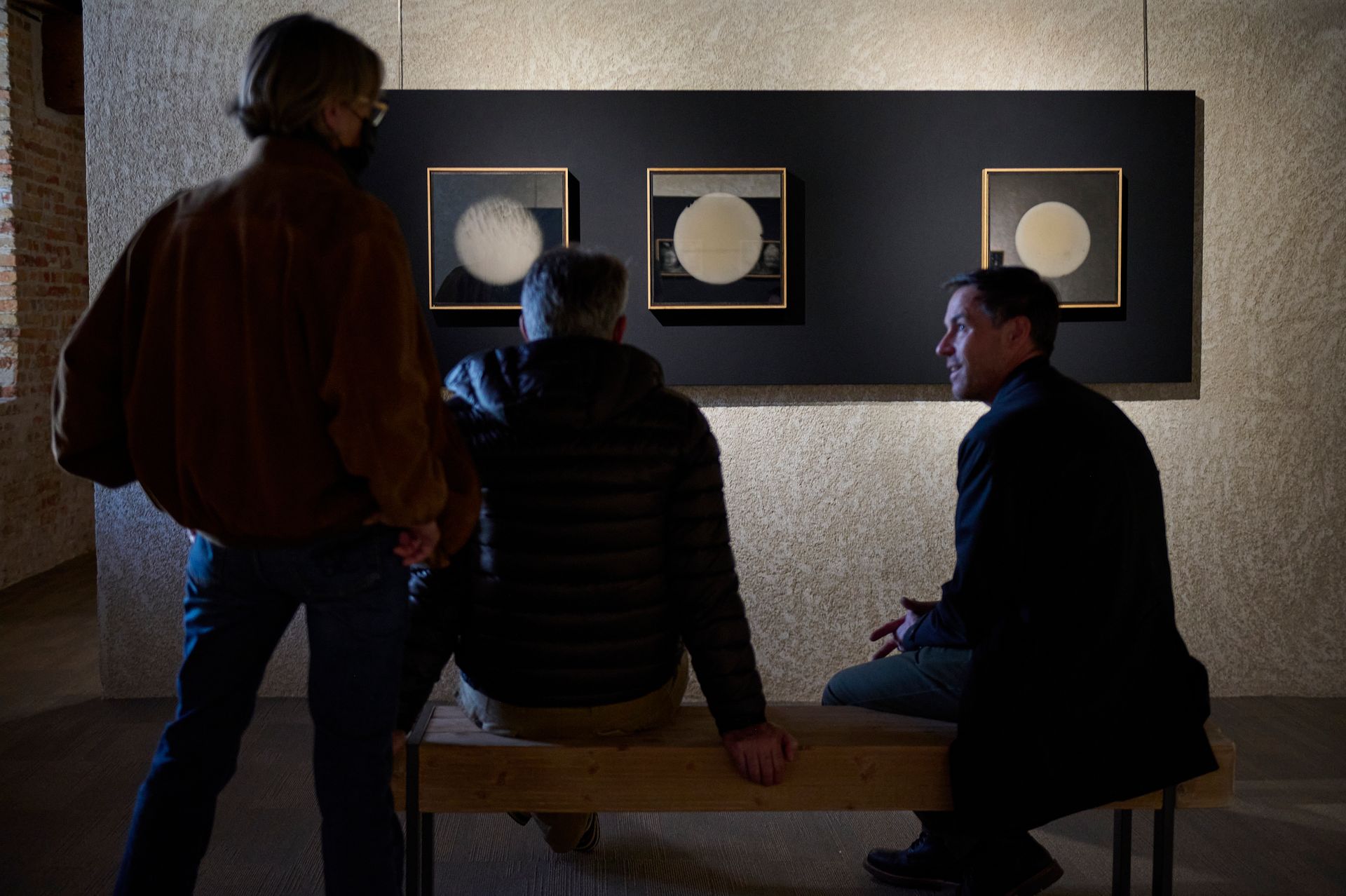 Public discutant avec un artiste devant ses oeuvres à un vernissage