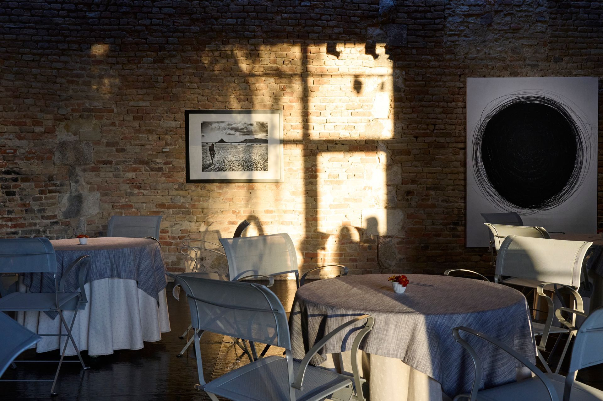 Jeu de lumière d'une fen^tre sur des peinture, des sculptures et un mur en pierre