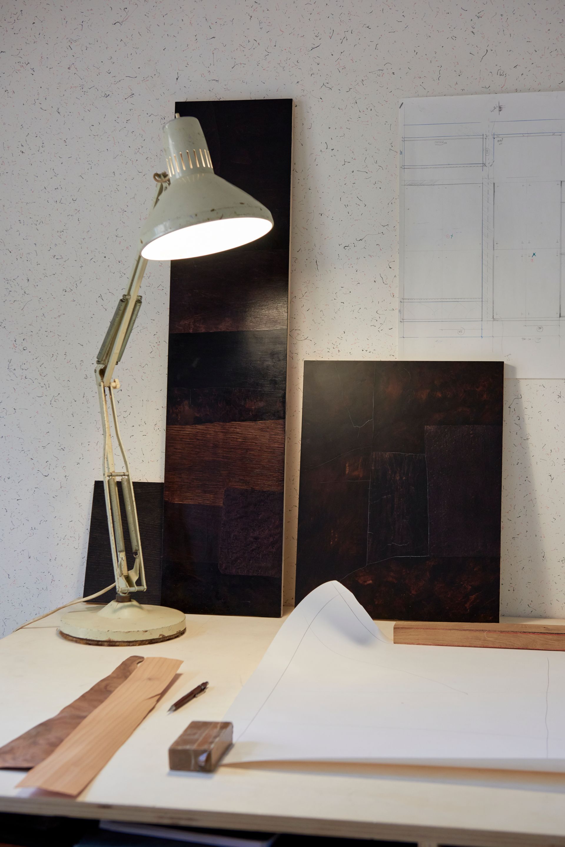 Lampe d'architecte et tableau de marqueterie sur un bureau