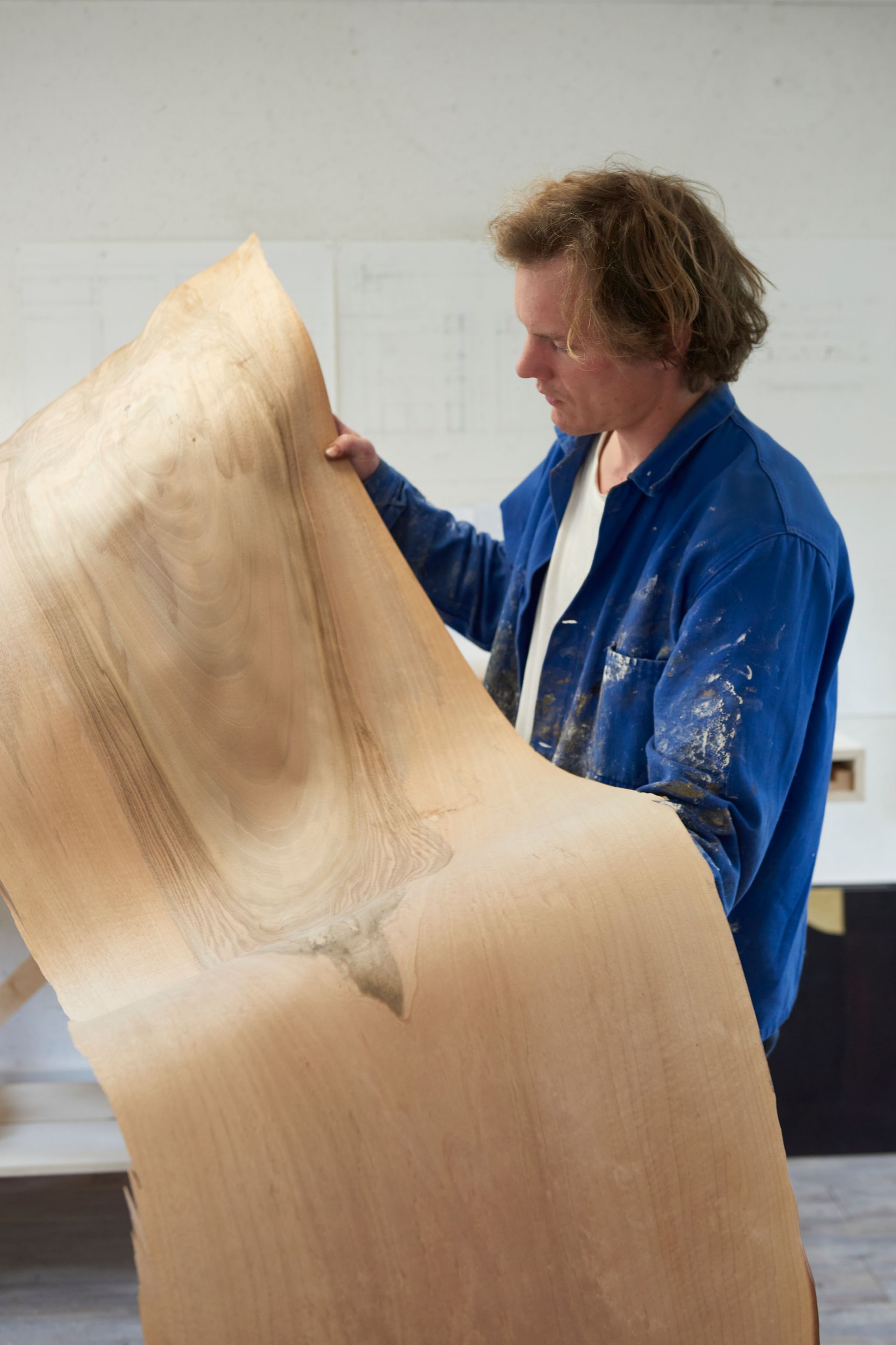 Clément Barbier, ébéniste lisant une feuille de bois