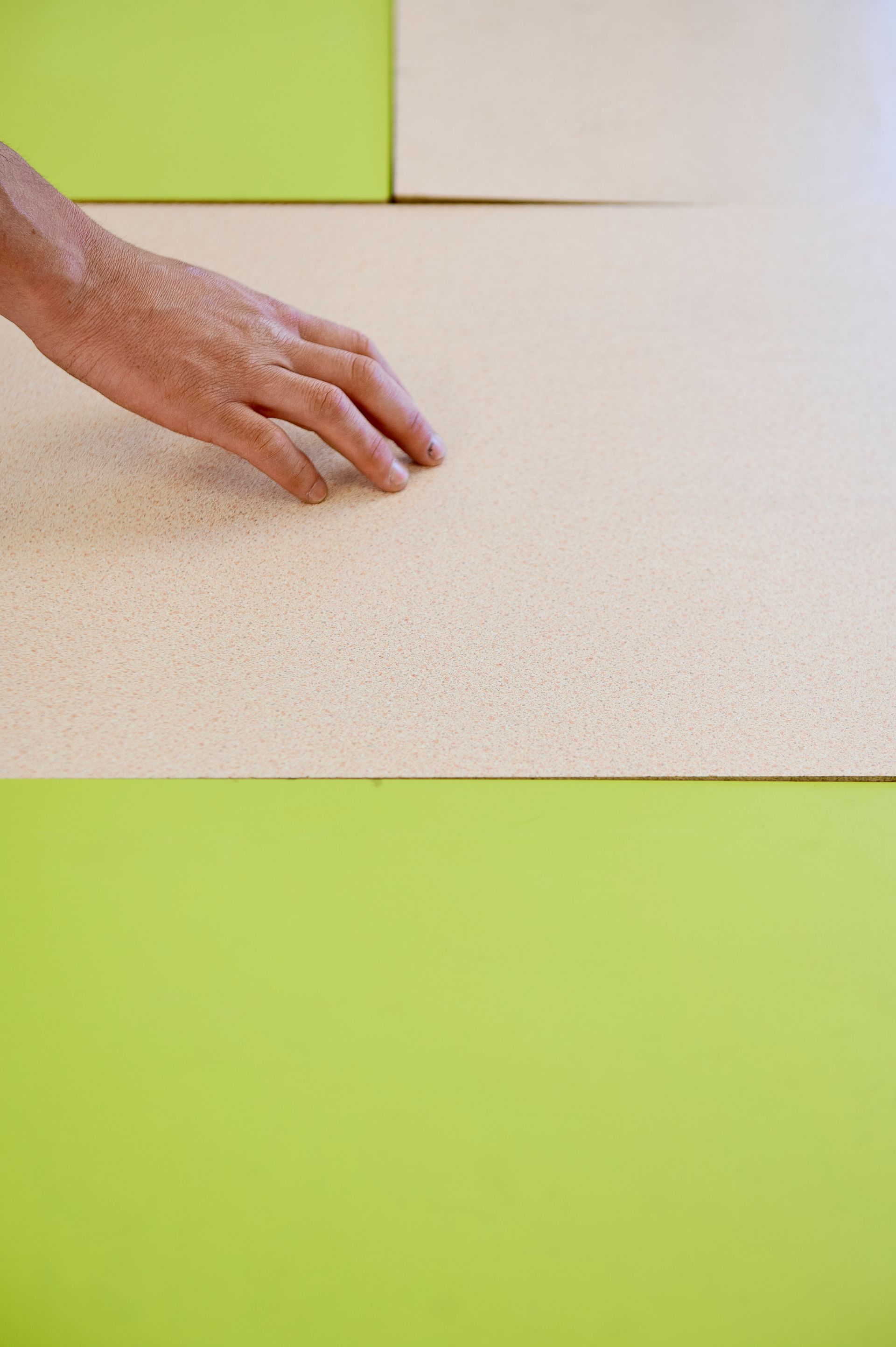 Main devant des planche protégeant le bois sous la presse