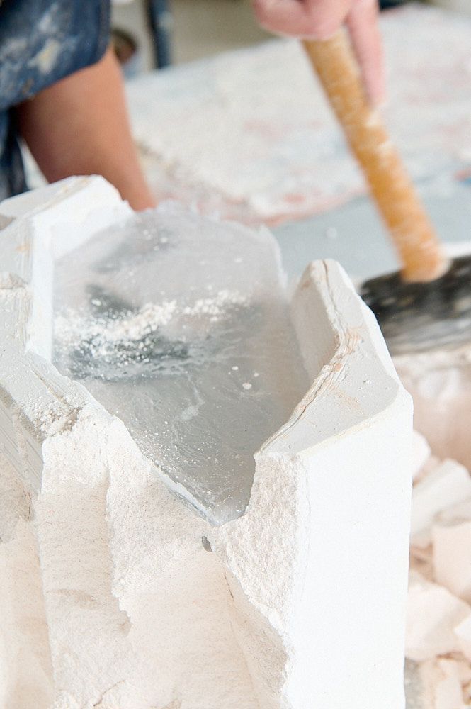 Marteau tapant sur le moule d'une œuvre en pâte de verre