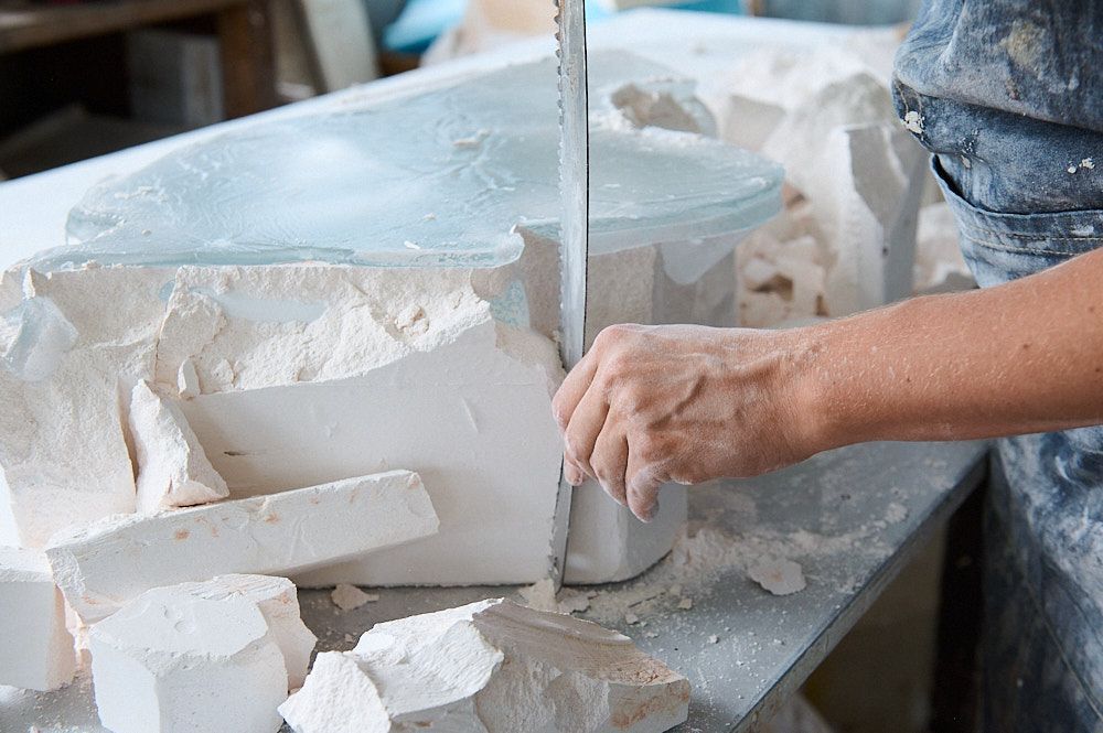 Scie devant une sculpture en verre