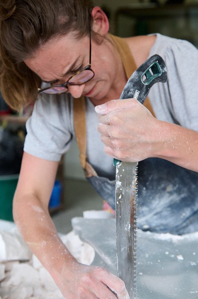 Artiste cassant du plâtre avec une scie