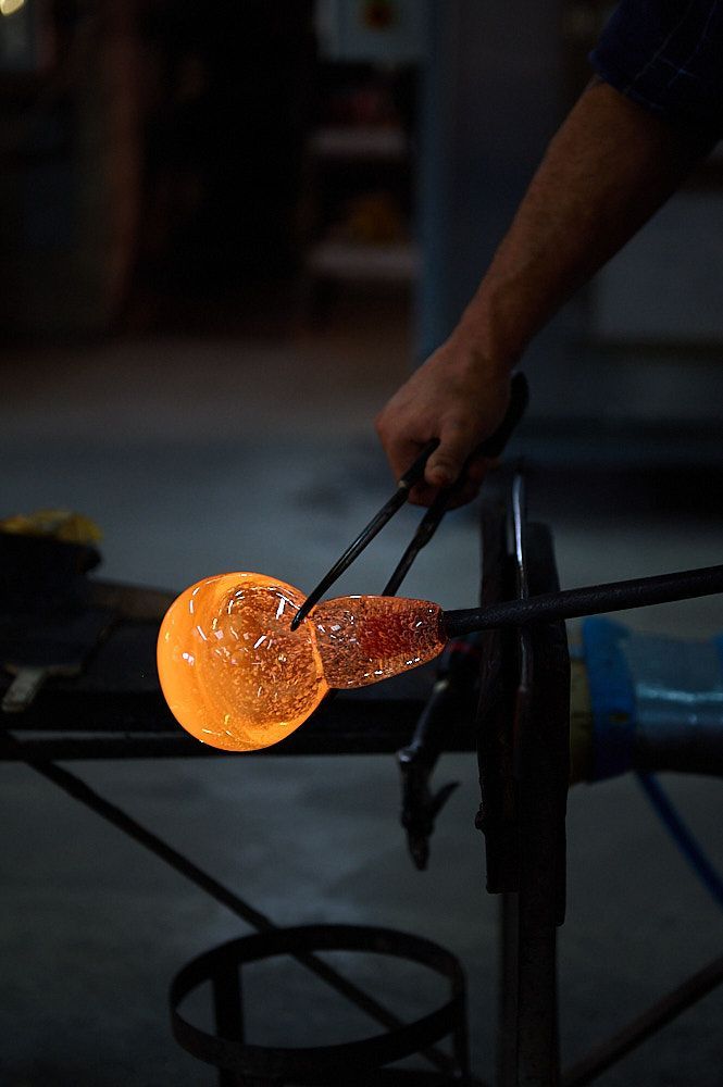 Boule de verre chaud en cours de soufflage au bout d'une canne