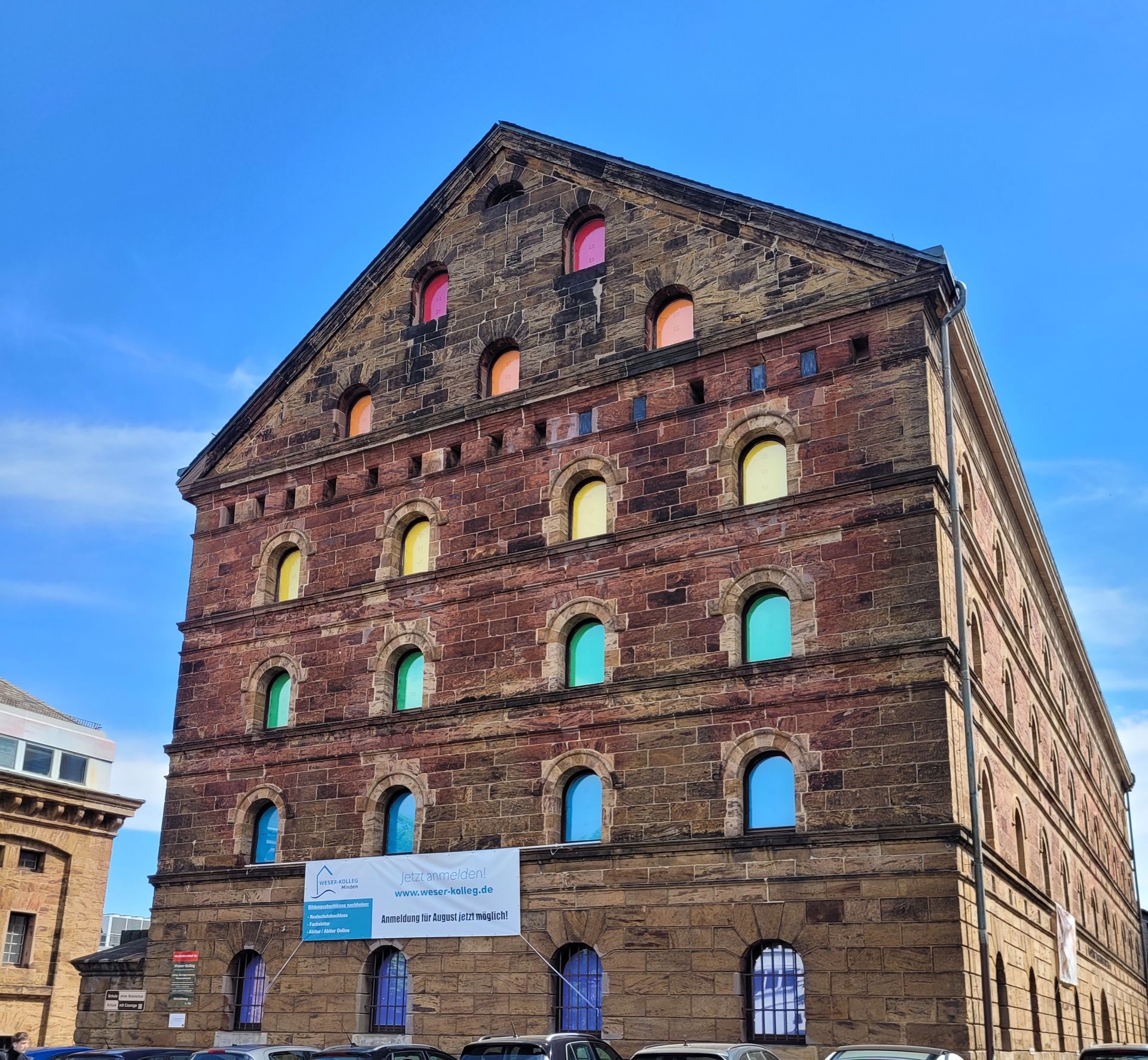 Foto der Schule mit Fenstern in Regenbogenfarben