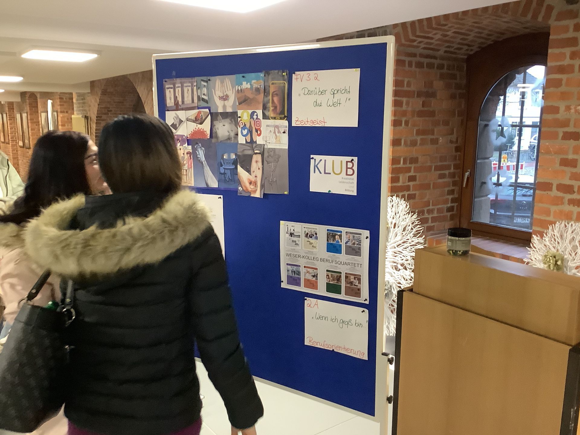 Foto von Studierenden, die Plakate betrachten