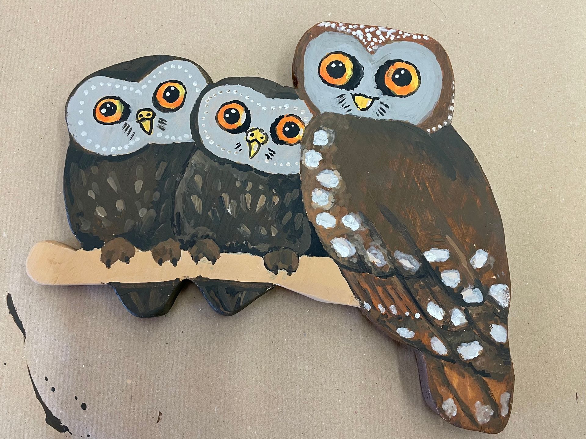 Kunstobjekt aus Holz: drei Eulen auf einem Ast