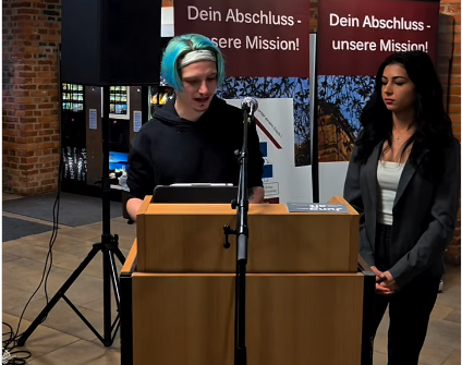 Foto von 2 Studierenden bei der Podiumsdiskussion