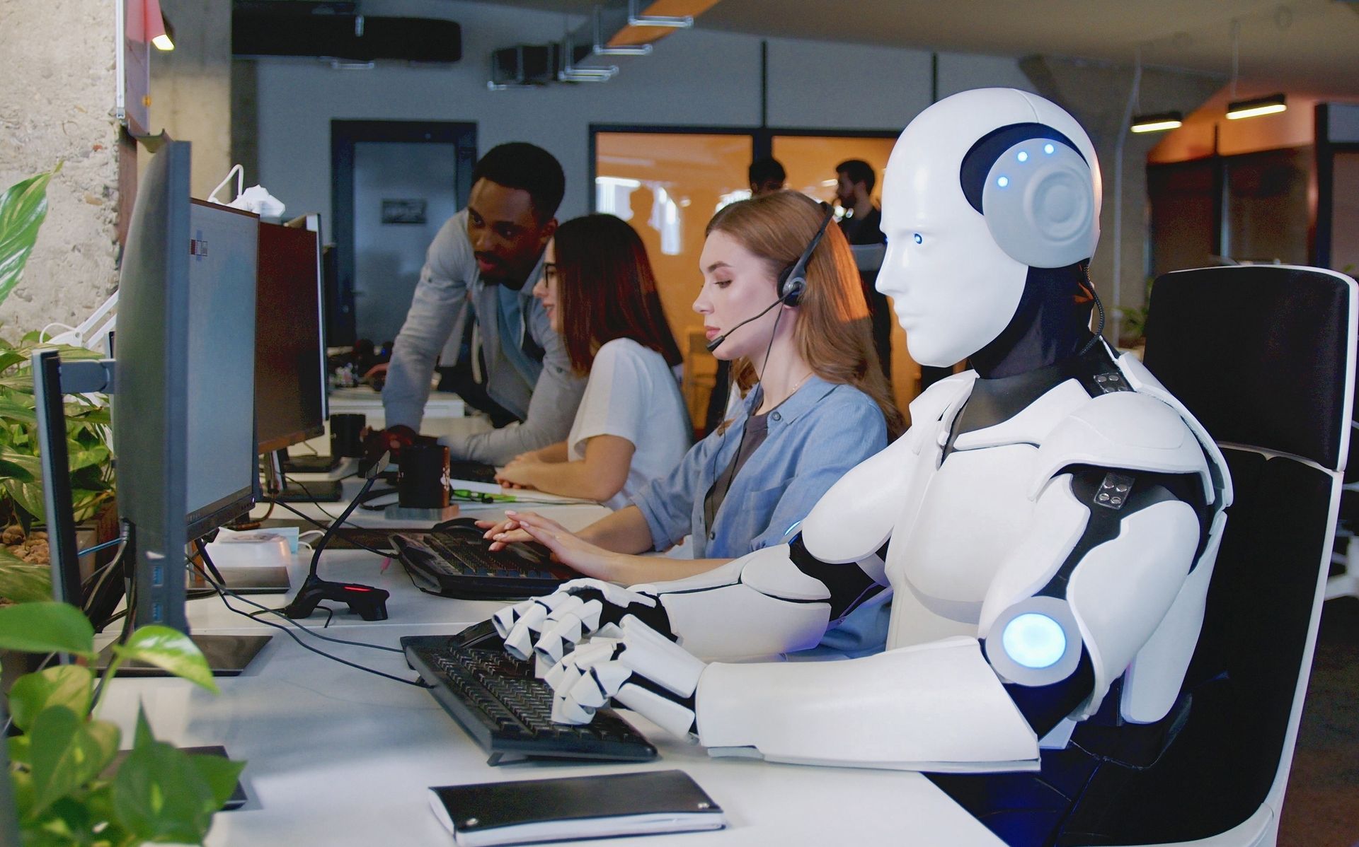 Kollege Roboter arbeitet im Büro mit menschlichen Mitarbeiterinnen und Mitarbeitern zusammen