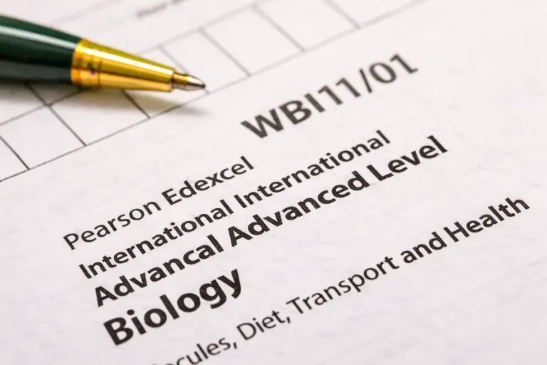 Close-up of Pearson Edexcel IAL Biology Unit 1 exam paper WBI11/01 with pen