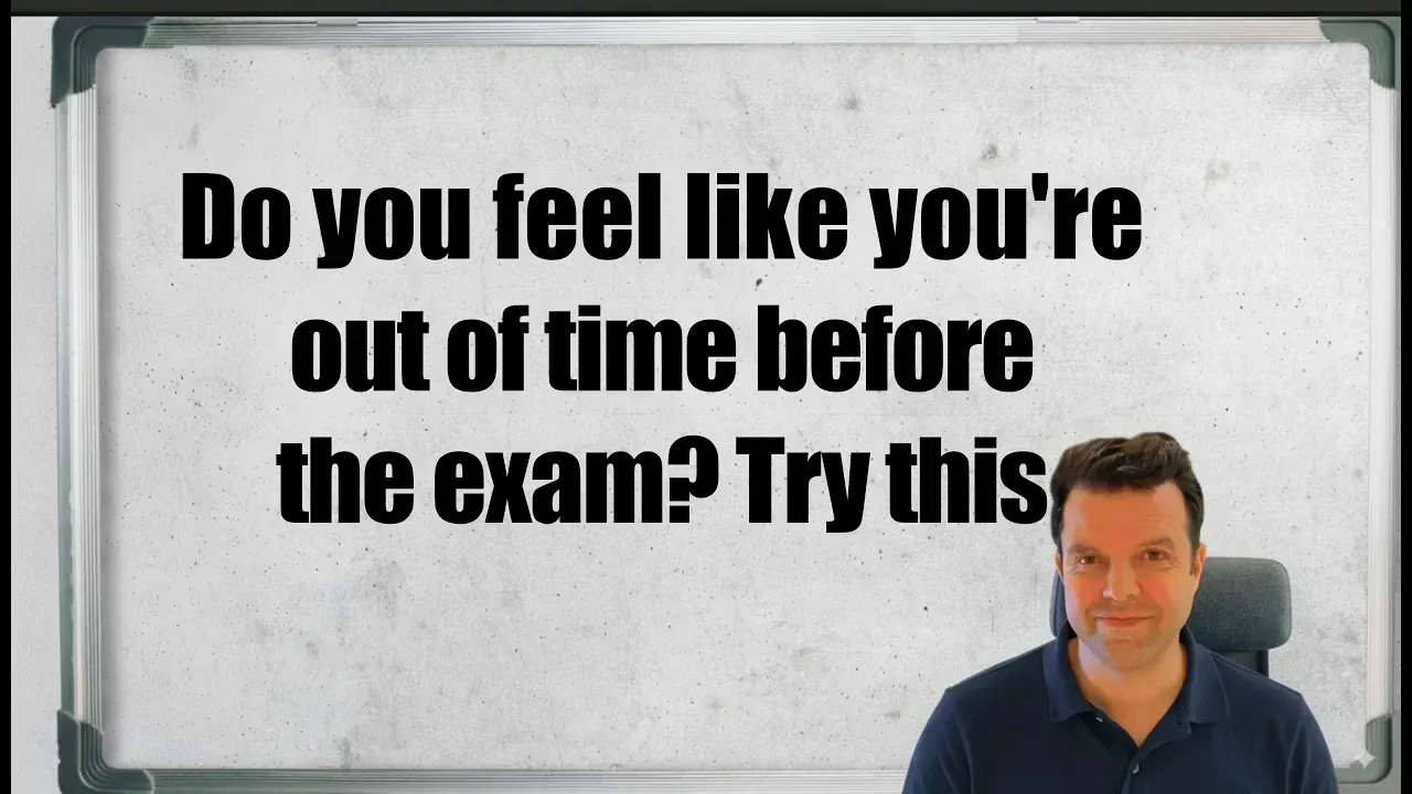 A man in a blue polo shirt sits before a whiteboard with