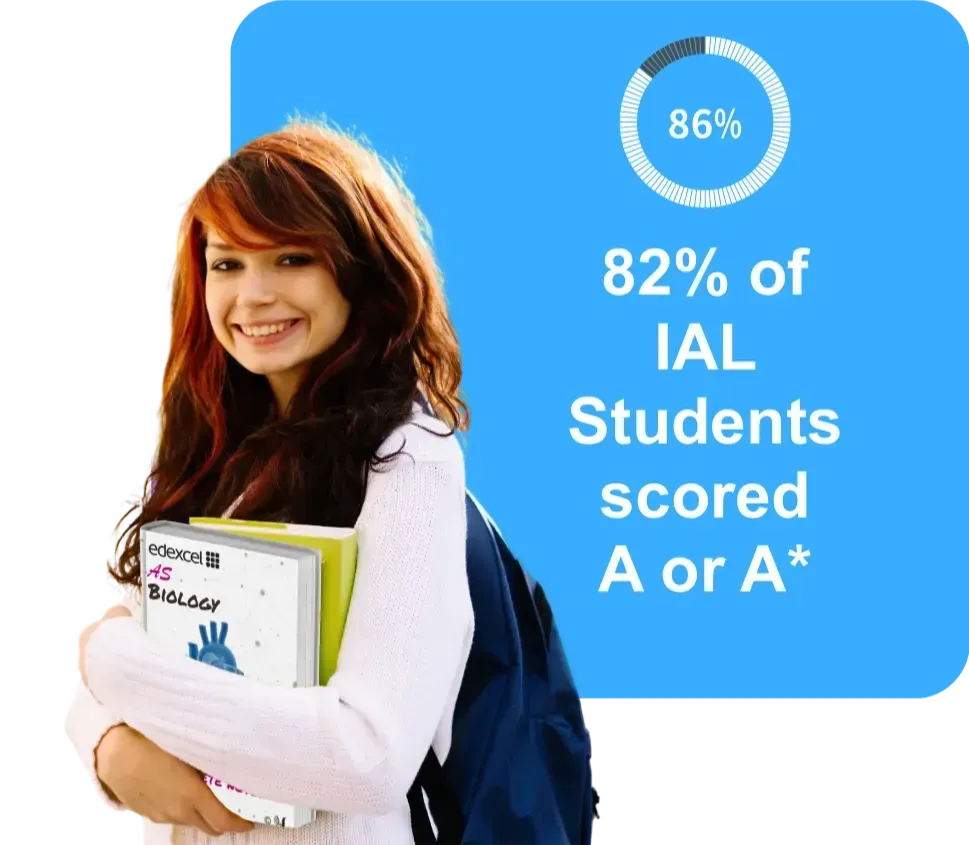 Smiling student with books stands by a blue panel:
