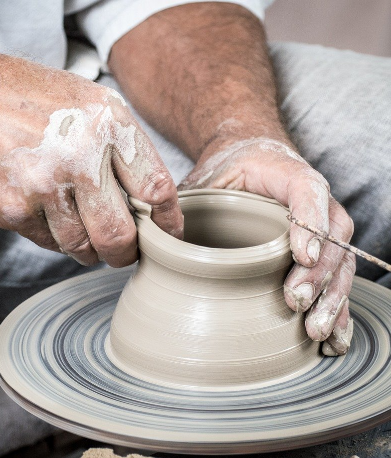 Image of hands shaping clay on a pottery wheel.