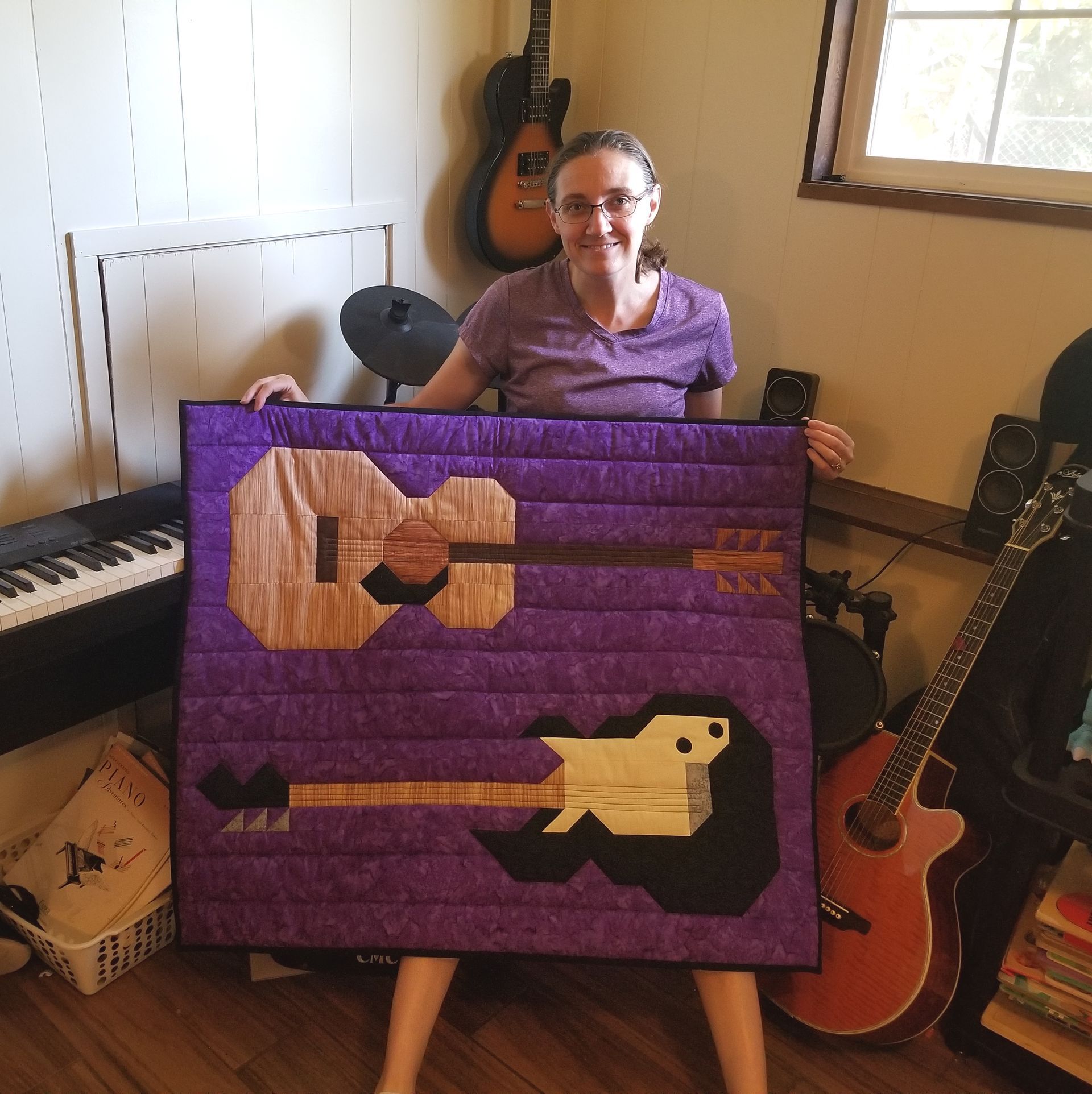 Design Lisa Muilenburg holding Guitar quilt