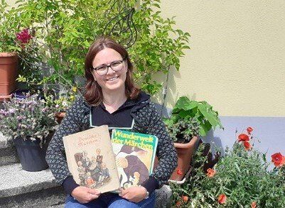 Maria Weidinger mit zwei alten Märchenbüchern