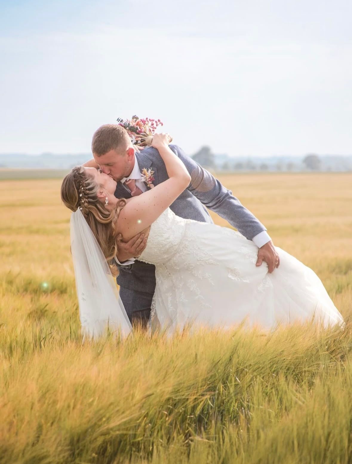 Newlyweds sharing a kiss during rustic countryside farm wedding in Lincolnshire