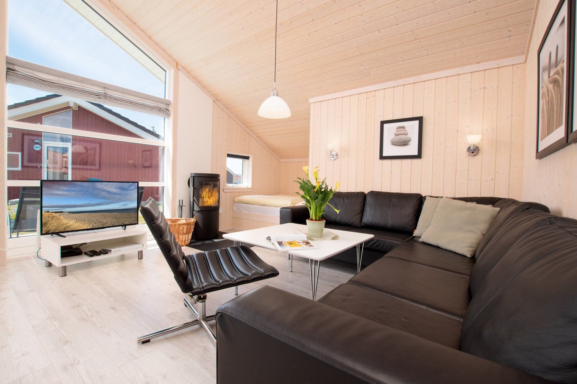 Große Sitzecke im Wohnzimmer mit Fernseher und Kaminofen