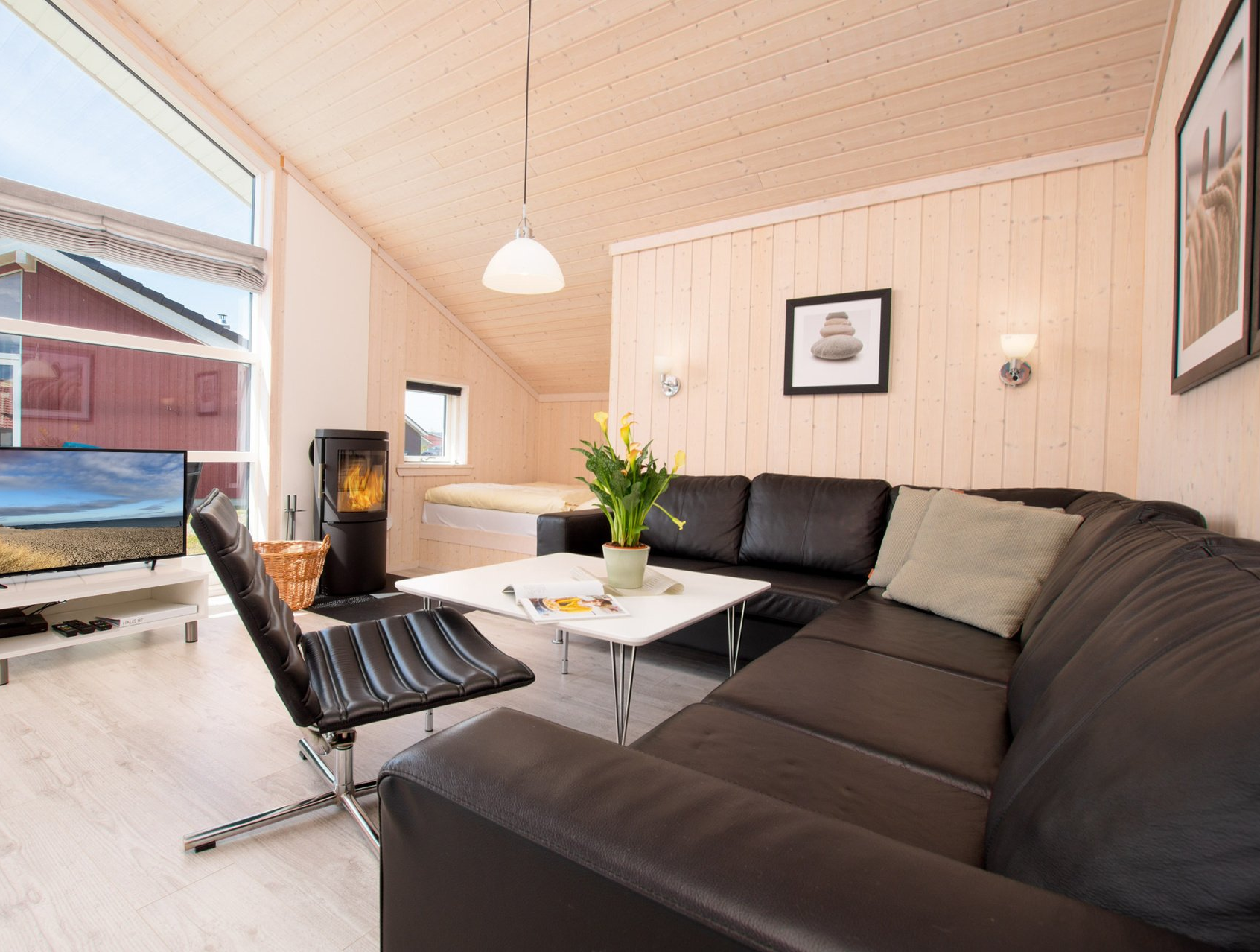 Große Sitzecke im Wohnzimmer mit Fernseher und Kaminofen