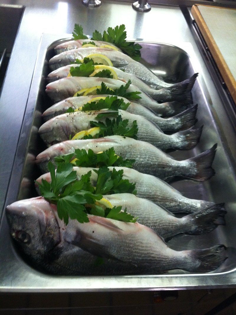 Eine Reihe von Fischen, die für den Partyservice vorbereitet werden.