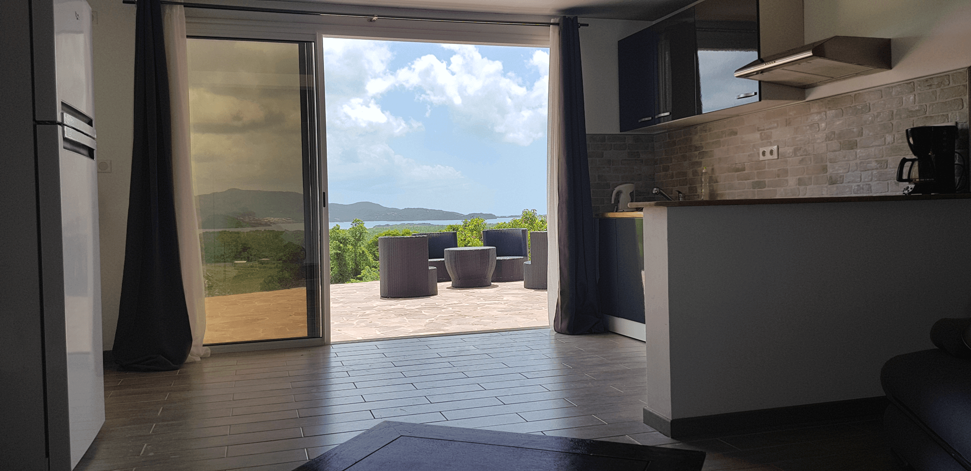 Salon Cuisine Terrasse avec vue sur Baie de Fort-de-France Martinique. SurlaBaie.fr Location Saisonnière Appartement F2 à louer à la semaine avec vue sur la Baie de Fort de France à Ducos. Location de vacances en Martinique. Maison avec piscine et jardin avec vue sur la Baie de Fort-de-France