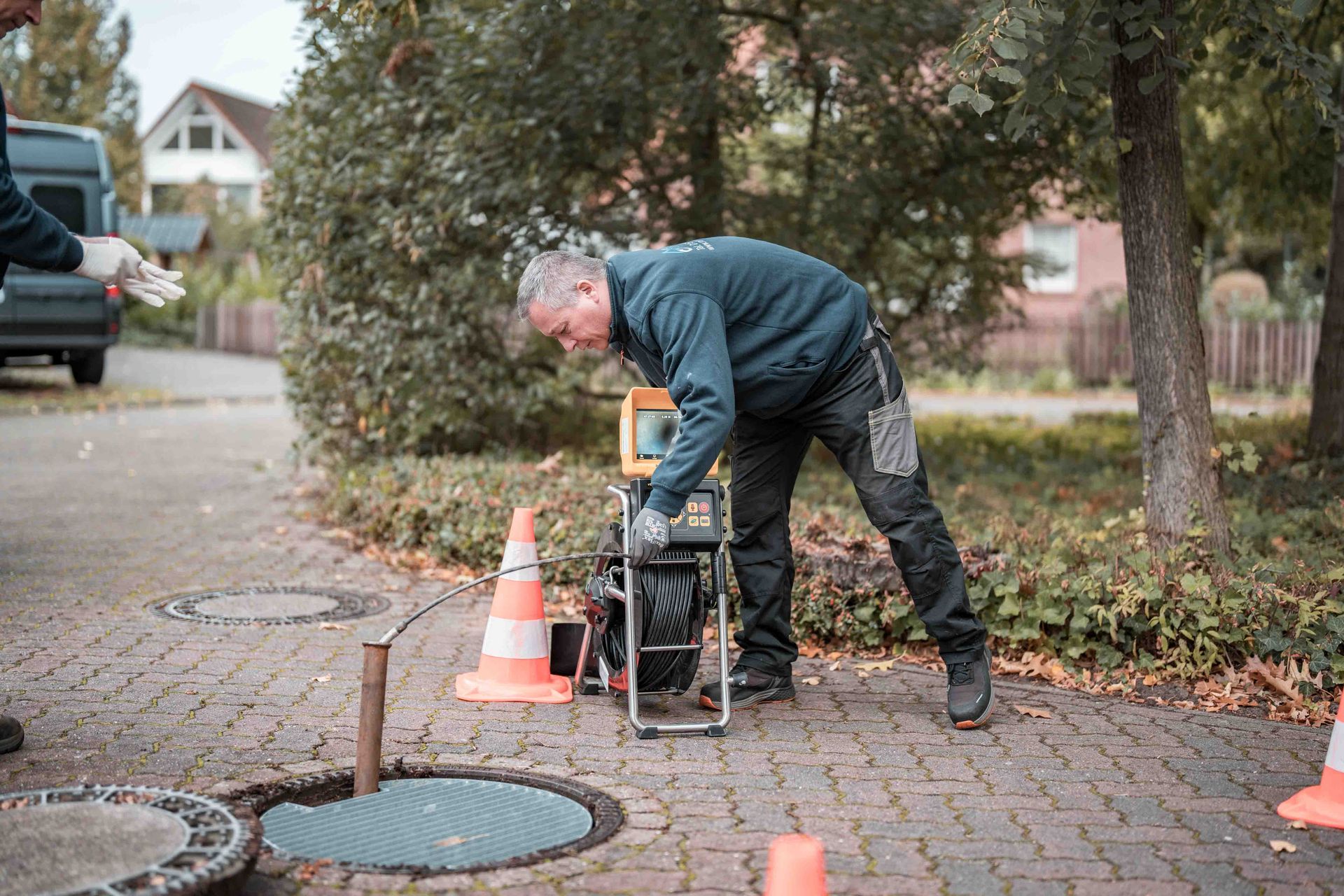 Das Bild zeigt ihn in einem Abwassersystem, während er die Kamera durch die Rohre führt, um den Zustand zu überprüfen