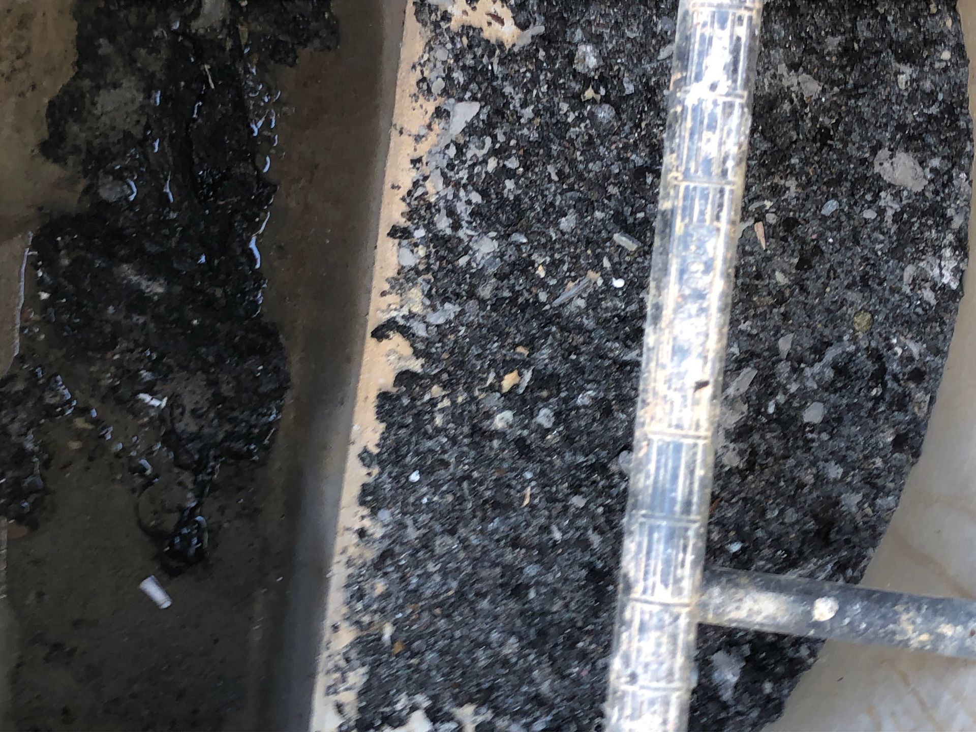 Reste von Asphalt im Übergabeschacht. Diverser Übergabeschacht mit Ablagerungen und Asphaltresten.