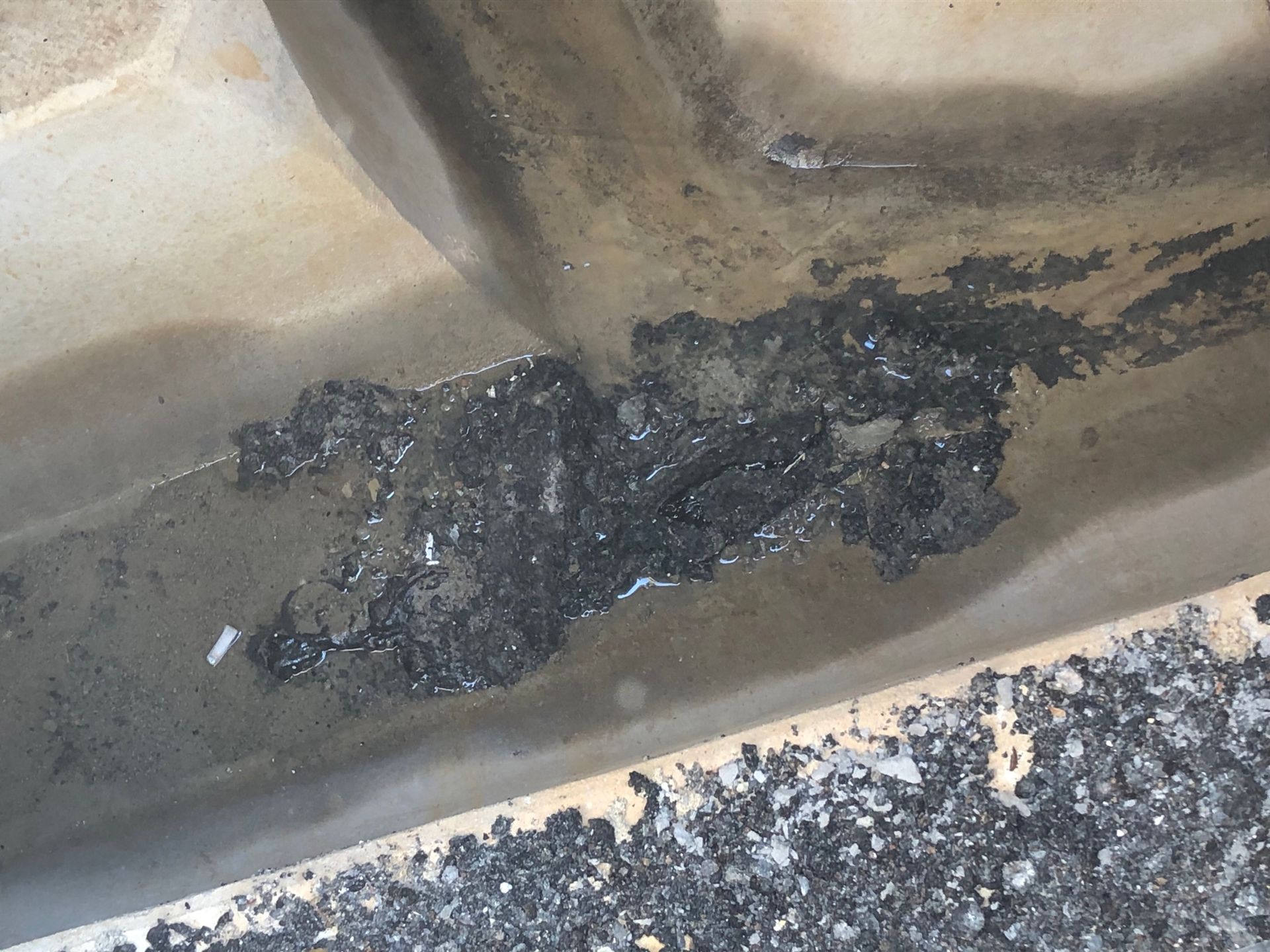 Asphaltreste im Schacht. Asphaltreste und Ablagerungen im Übergabeschacht. Rohrreinigung für Helvesiek.