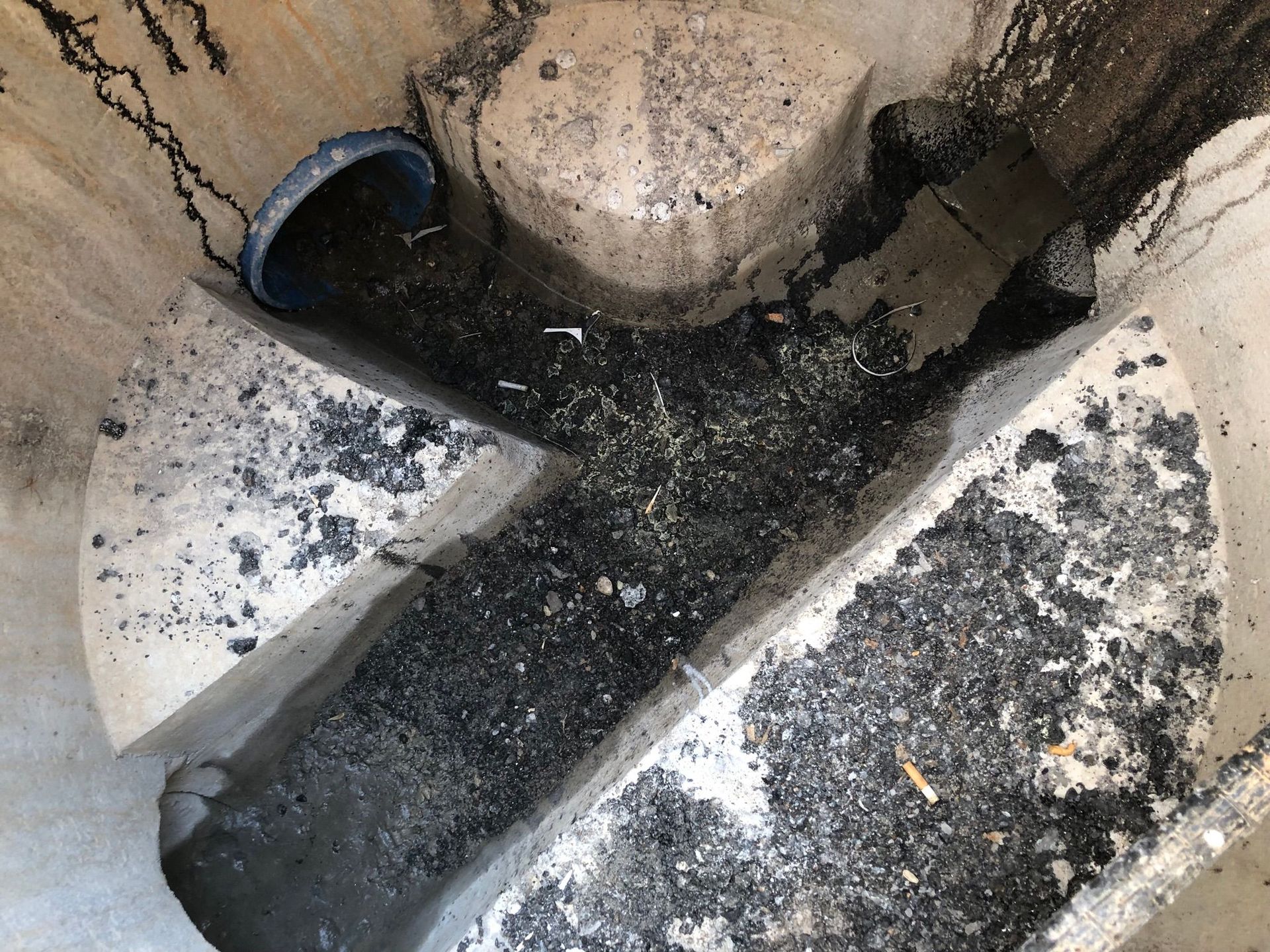 Asphalt und Bauschutt im Schacht. Asphaltreste, Bauschutt im Übergabeschacht und in der Grundleitung.
