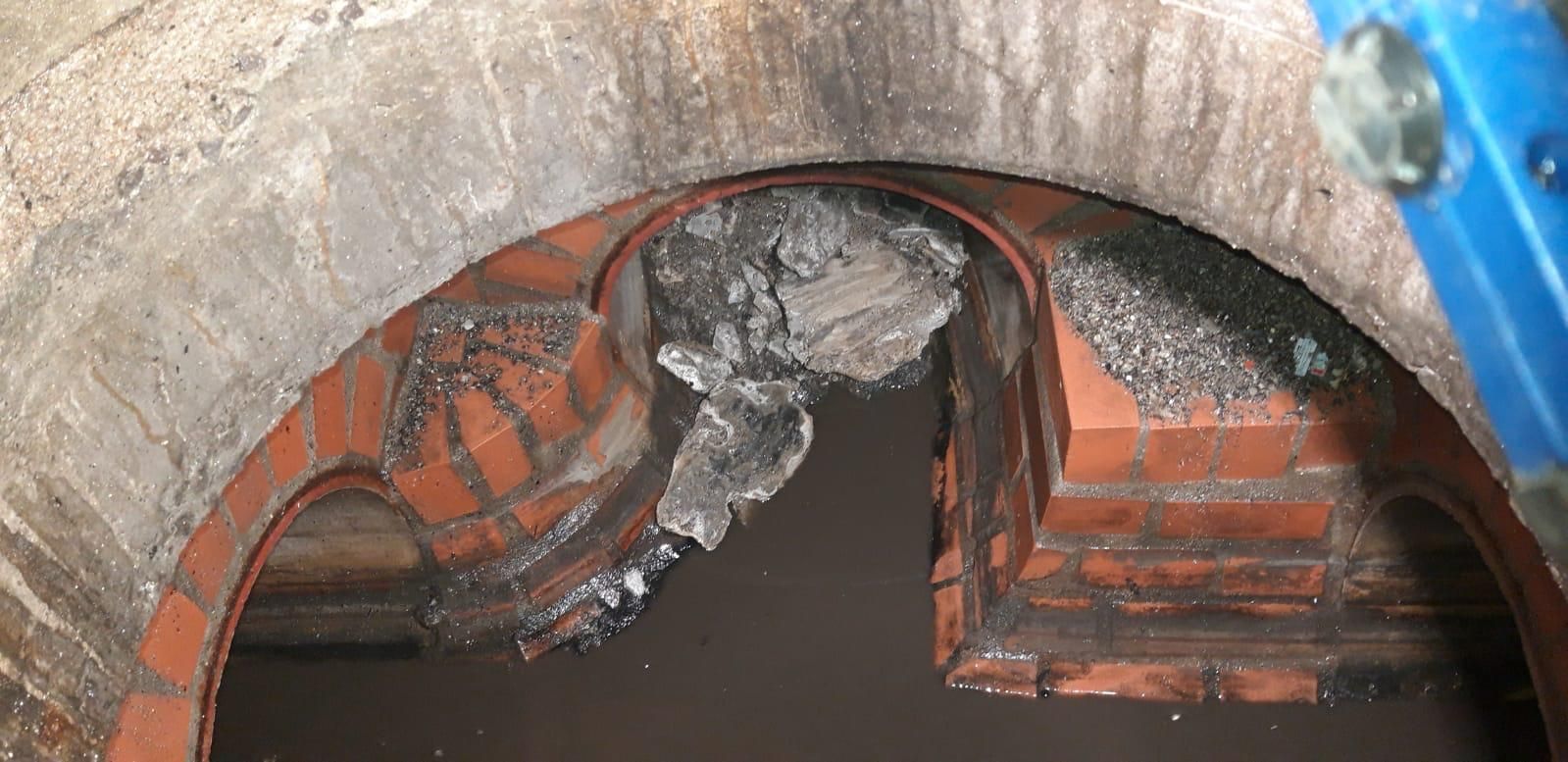 Ablagerungen in einem Übergabeschacht. Schacht voll mit Ablagerungen und Urinstein - Rohrfrei Direkt Rohrreinigung.