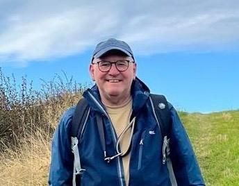 Photograph of Wayne Mann, outdoors, wearing hiking gear.