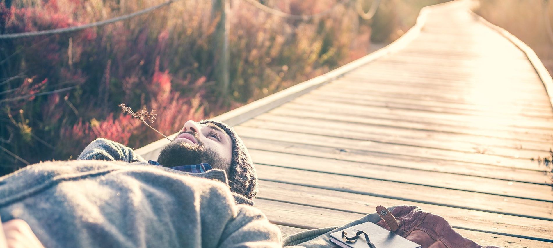 person laying on decking relaxing, taking time for themselves promoting wellness and self care