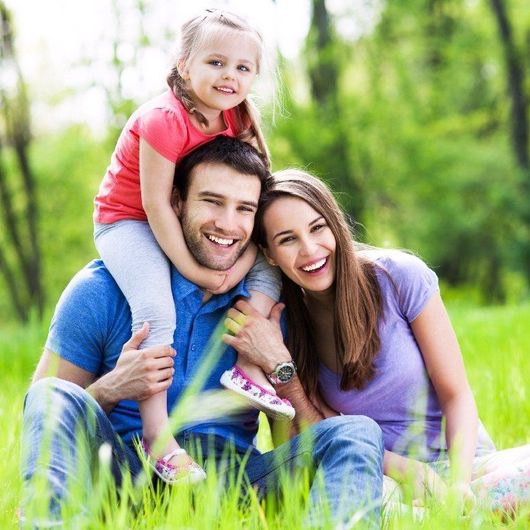 Happy Couple With Their Daughter on The Fathers Shoulders Smiling