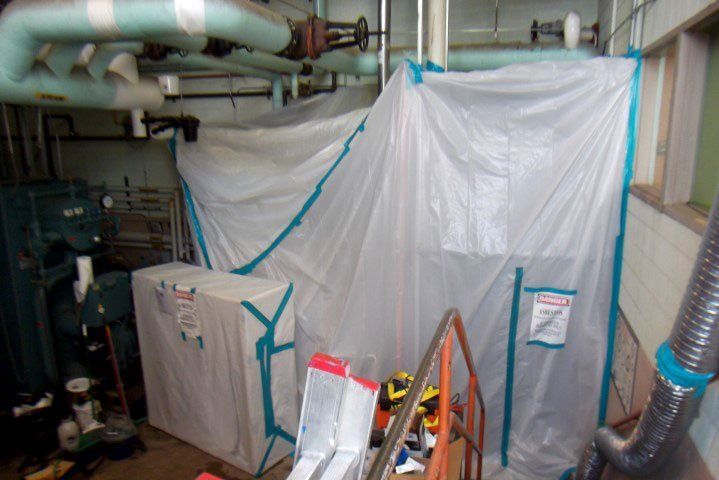 Tarp & Tape Blocking Off A Portion of A Room with Exposed Pipes