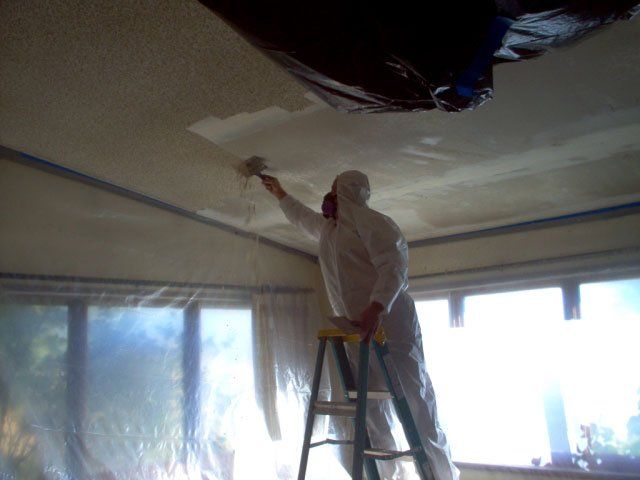 Man Scraping A Popcorn Ceiling