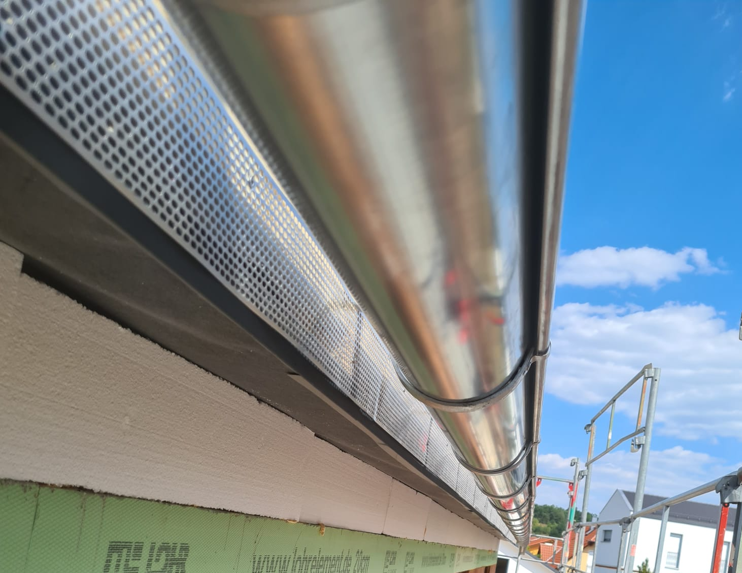 Eine neu montierte Dachrinne, perfekt ausgerichtet und in der Flucht fotografiert – modernes Handwerk für optimalen Wasserabfluss.