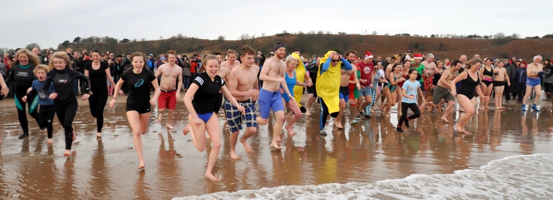 New Year's Day swimmers  rush towards  the sea