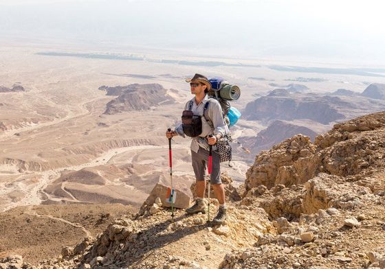 Man with backpacking gear hiking through mountain