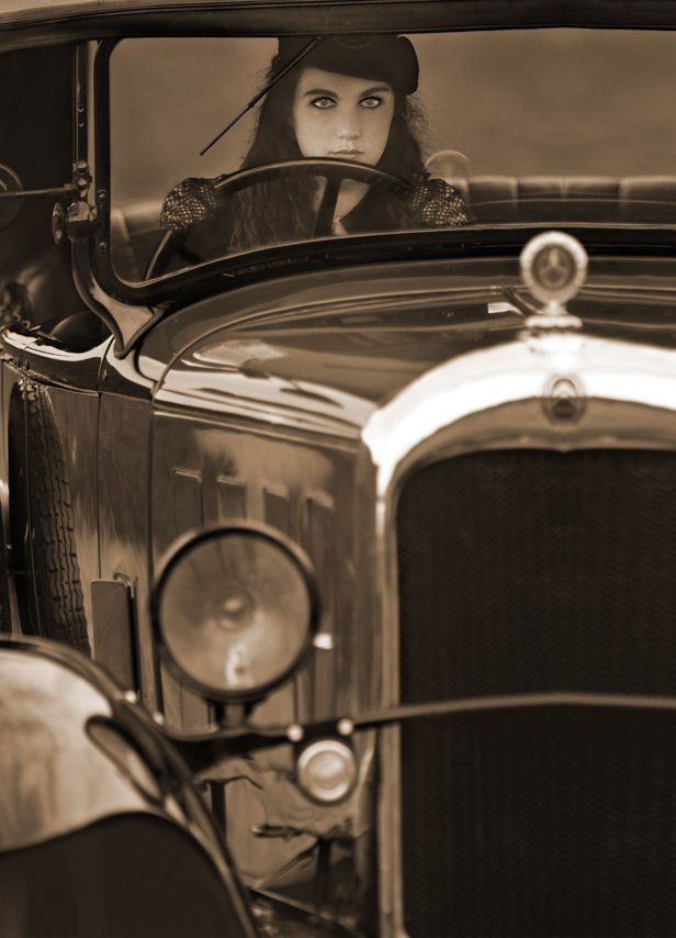Photo sépia d'Albane en Bonnie, de face, conduisant une Citroën C4 Torpedo , portant un chapeau serre-tête noir de Lilô Chapô