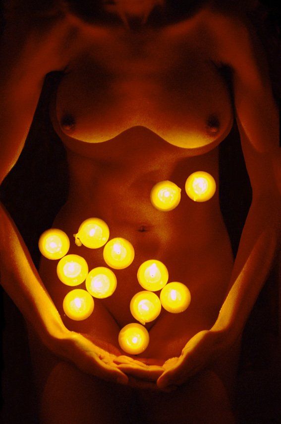 Thierry Aguiar : photo de Claudine nue allongée dans une baignoire, éclairée par des bougies flottantes.