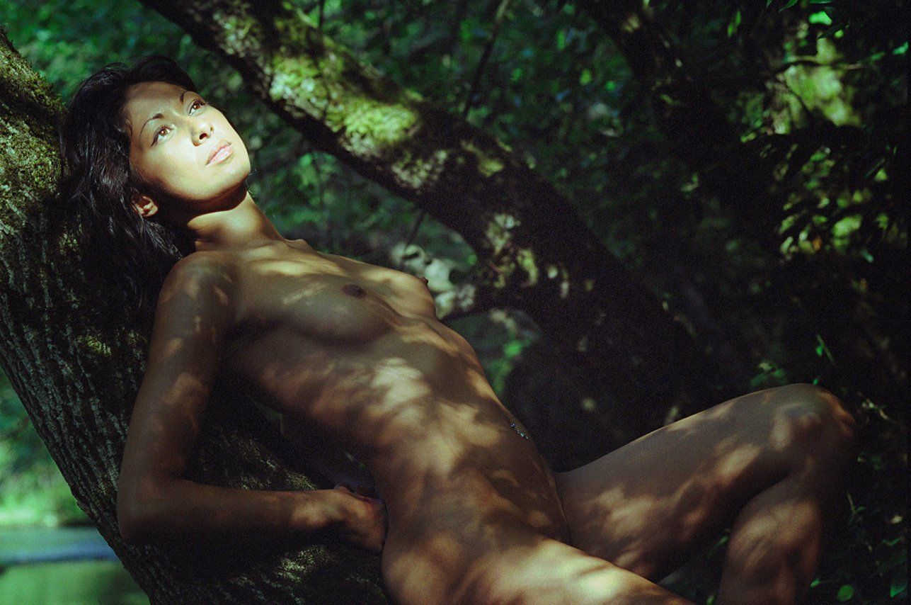 Thierry Aguiar : photo de Juliana nue allongée sur le dos sur un tronc d’arbre dans une forêt.