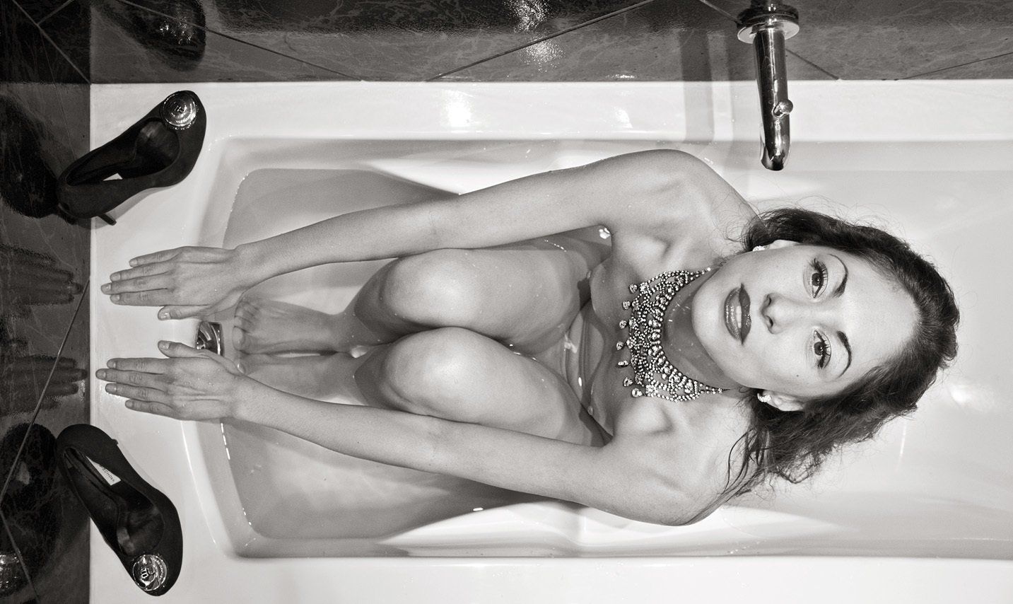 Thierry Aguiar : photo noir et blanc prise de dessus de Juliana, nue dans une baignoire, un collier autour du cou, prête pour un départ de dos crawlé.