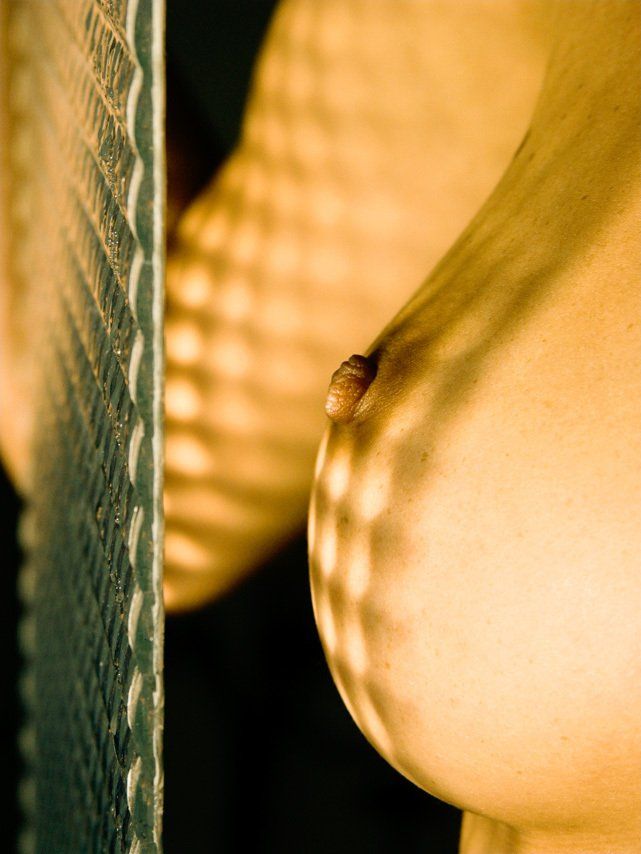 Thierry Aguiar : photo du sein de Sabrina de profil, une vitre gaufrée devant elle tenue à la main.