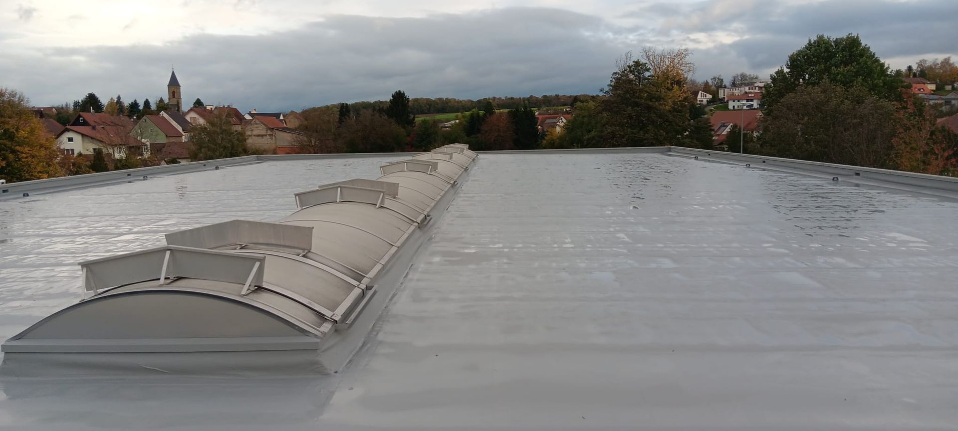 Flachdachsanierung mit Flüssigkunststoff und Vlies auf Foliendach