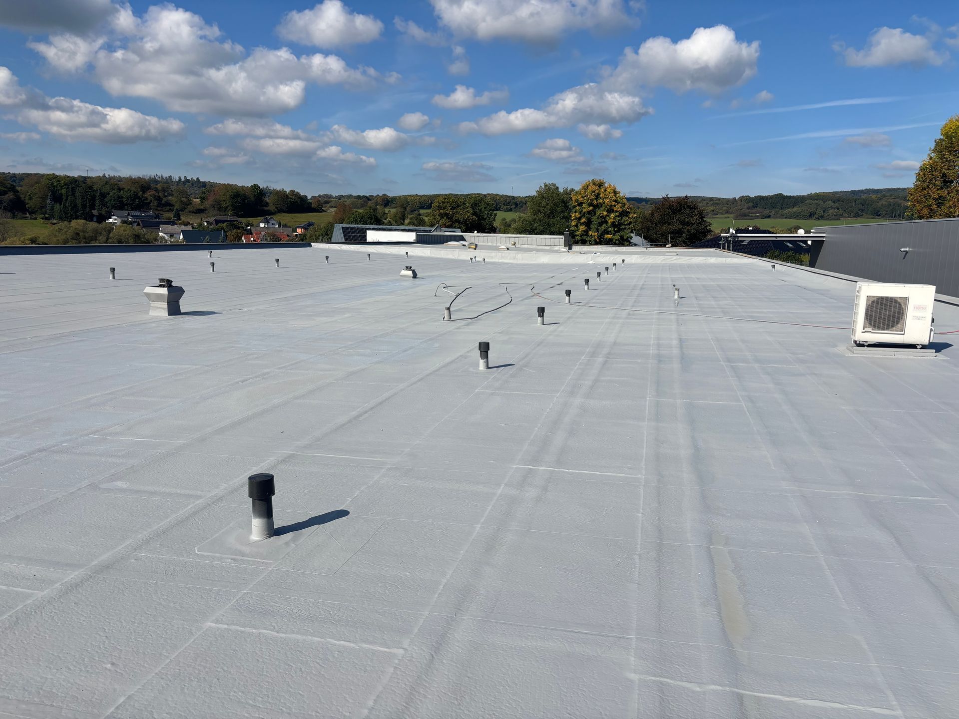 Flachdachsanierung mit Flüssigkunststoff und Vlies auf Bitumendach