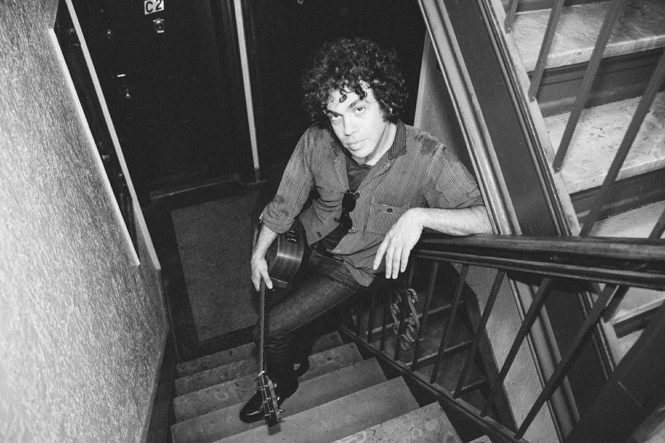 Matt Pless in stairwell with guitar