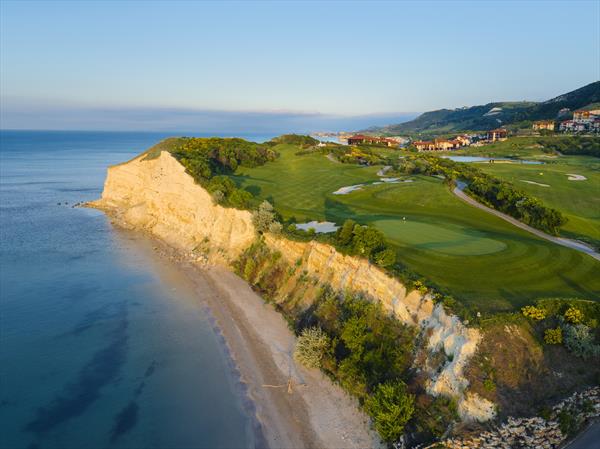 Clifftop golf course at Thracian Cliffs overlooking the Black Sea under a clear blue sky.