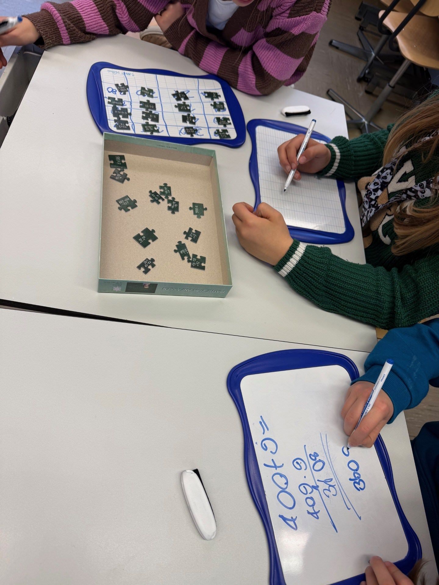 PLUZZLE Mathe-Puzzle im Team: Rasterrahmen legen, Puzzleteile mit Rechenaufgaben, Taschenrechner zur Unterstützung.